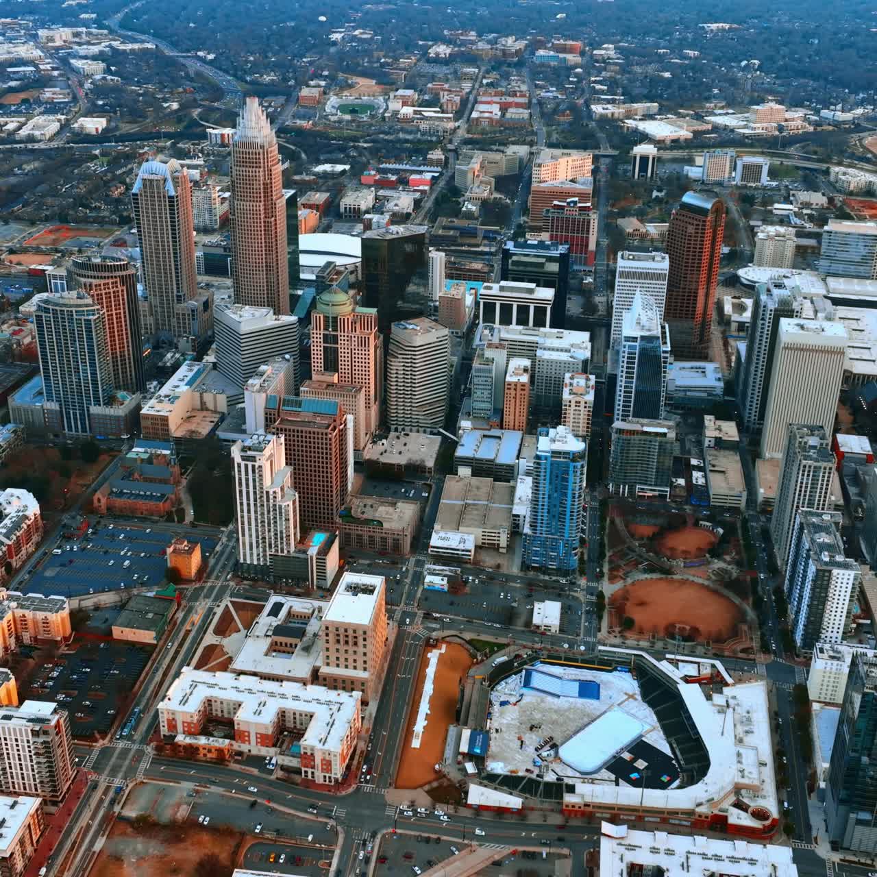 Hoog boven de binnenstad vliegen bij zonsondergang. Bovenaanzicht van Charlotte, North Carolina, VS