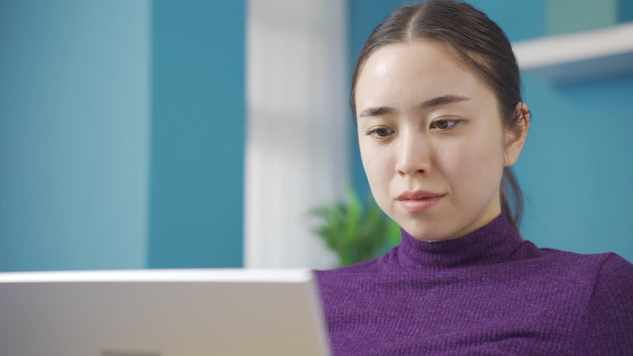una linda mujer asiática viendo una película de comedia en la computadora portátil.