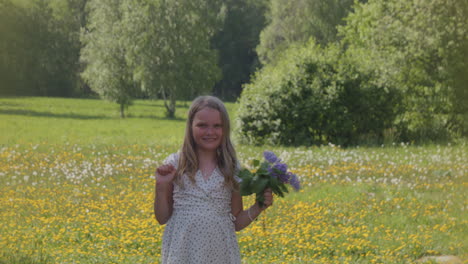 happy joyful girl with flowers in summer meadow