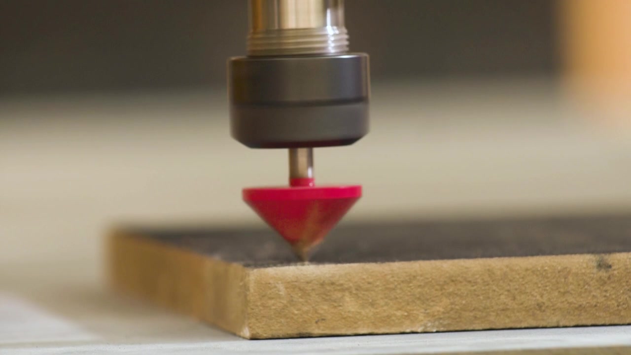 Incisione su MDF con macchina fresatrice CNC, vista laterale, rallentatore, detriti