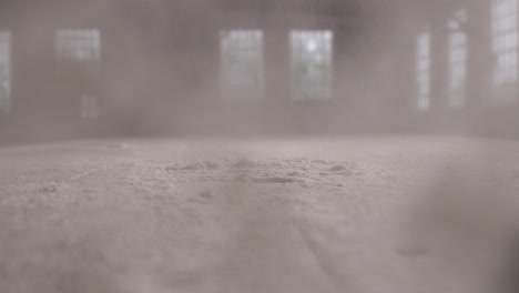 slow motion footage of a pile of flour being smashed with a hand and the flour covers the camera lens.