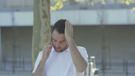 un joven molesto teniendo una mala conversación por teléfono.