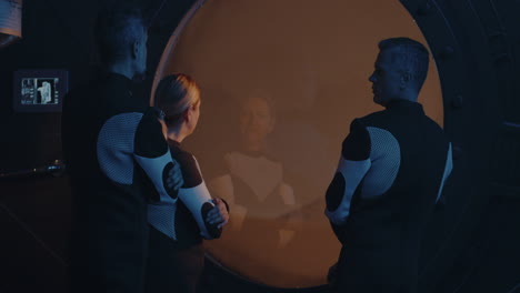 scientists observing through a large round window