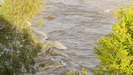 Río-Fuerte-Que-Fluye-Sobre-Un-Puente-Peatonal-Inundado