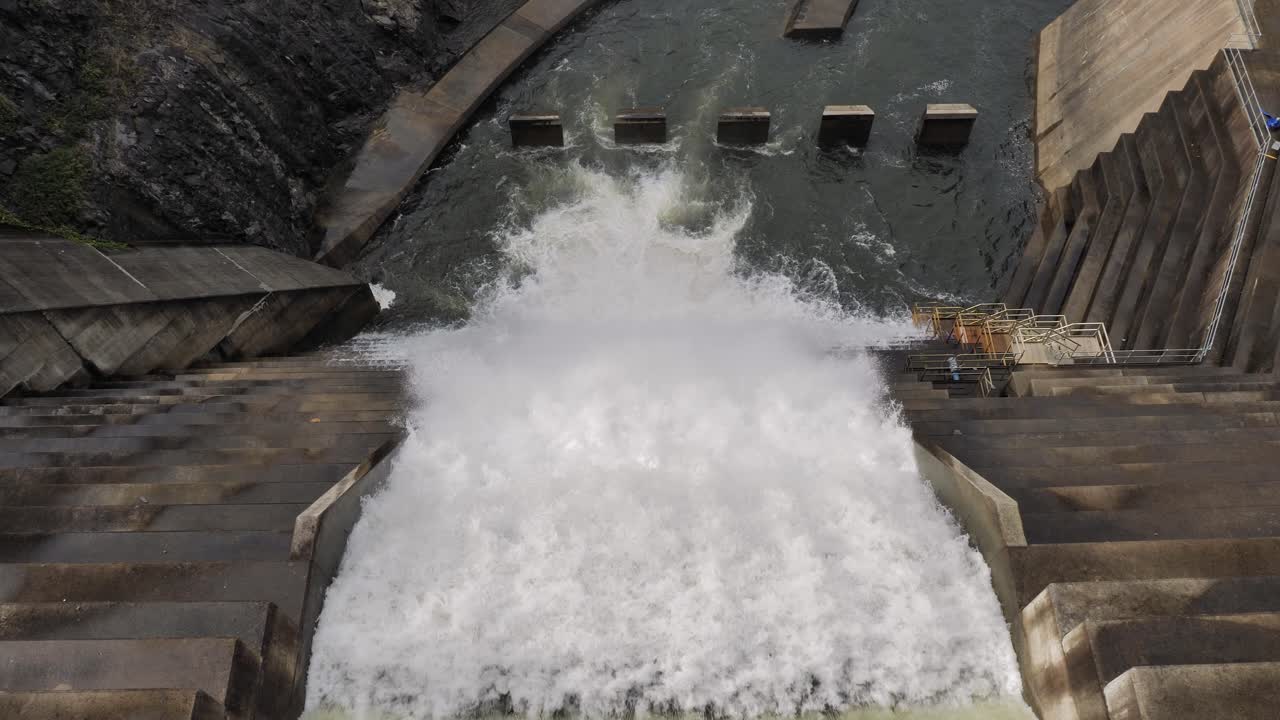 Top down medium view of water flowing through the Hinze Dam overflow due to ongoing heavy rains in the Gold Coast Hinterland