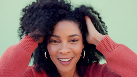 mujer negra, jugando con las manos en el cabello natural