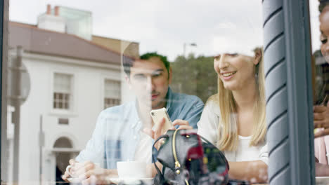 Freunde,-Die-Ihr-Smartphone-Benutzen-Und-Verbundenheit-Im-Café-Zeigen,-Lächeln-In-Zeitlupe