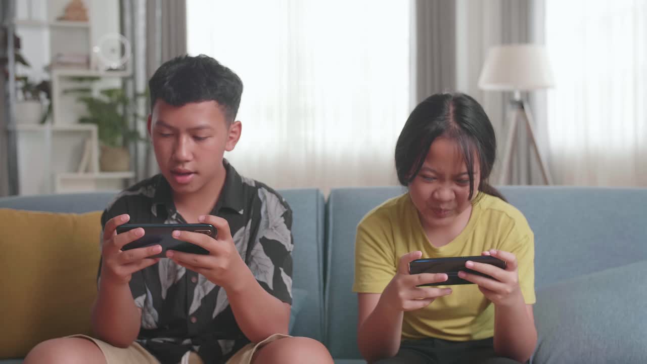 Children Playing Mobile Games on Couch