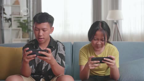 children playing mobile games on couch