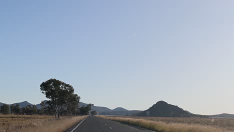 car traveling on a road amidst mountains and trees