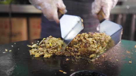 Cooking-Fried-Rice-With-Mushroom-On-Hot-Griddle-Using-Spatula-In-Kitchen