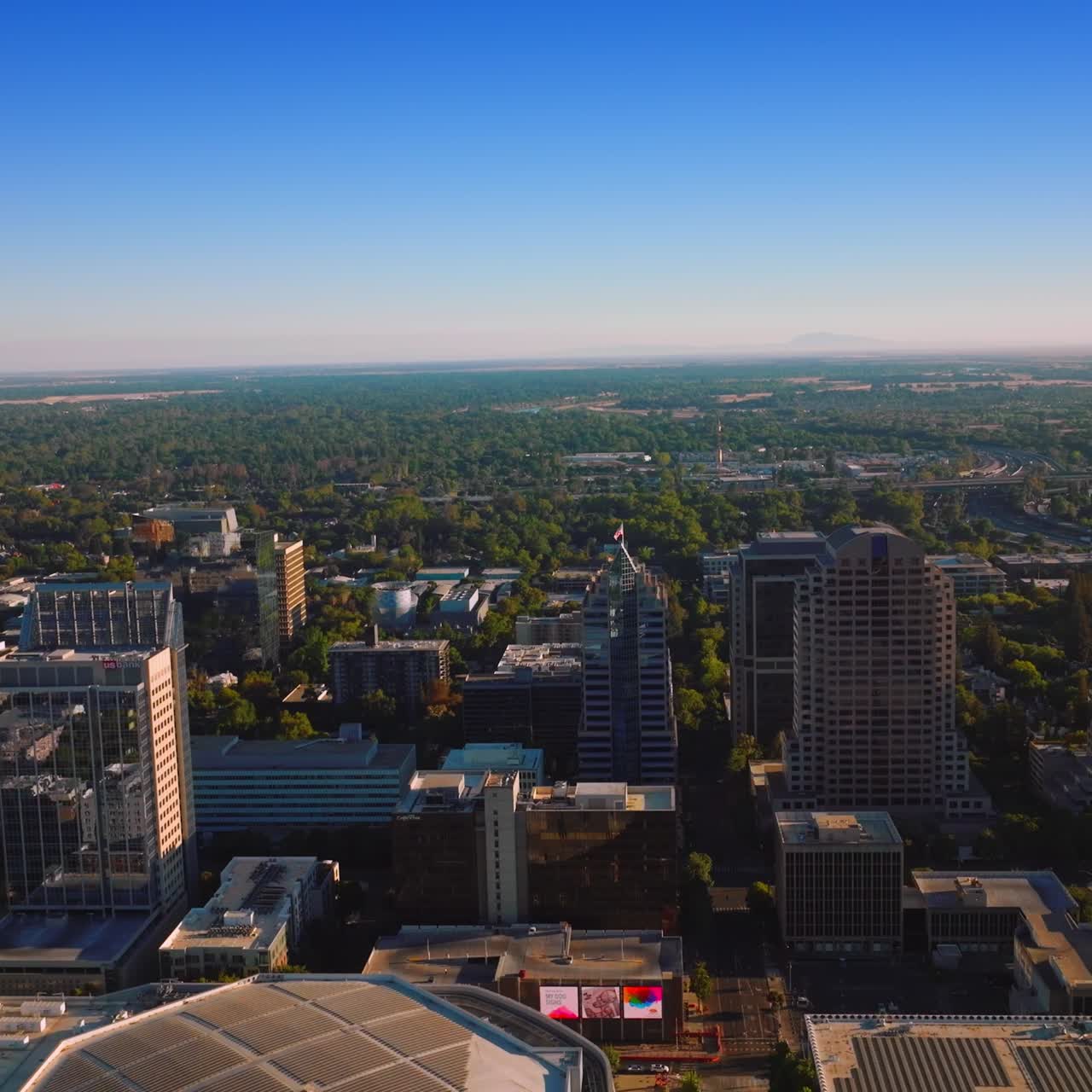 Rising over the beautiful capital of California State on bright sunny day. Modern buildings of Sacramento at the backdrop of clear blue sky