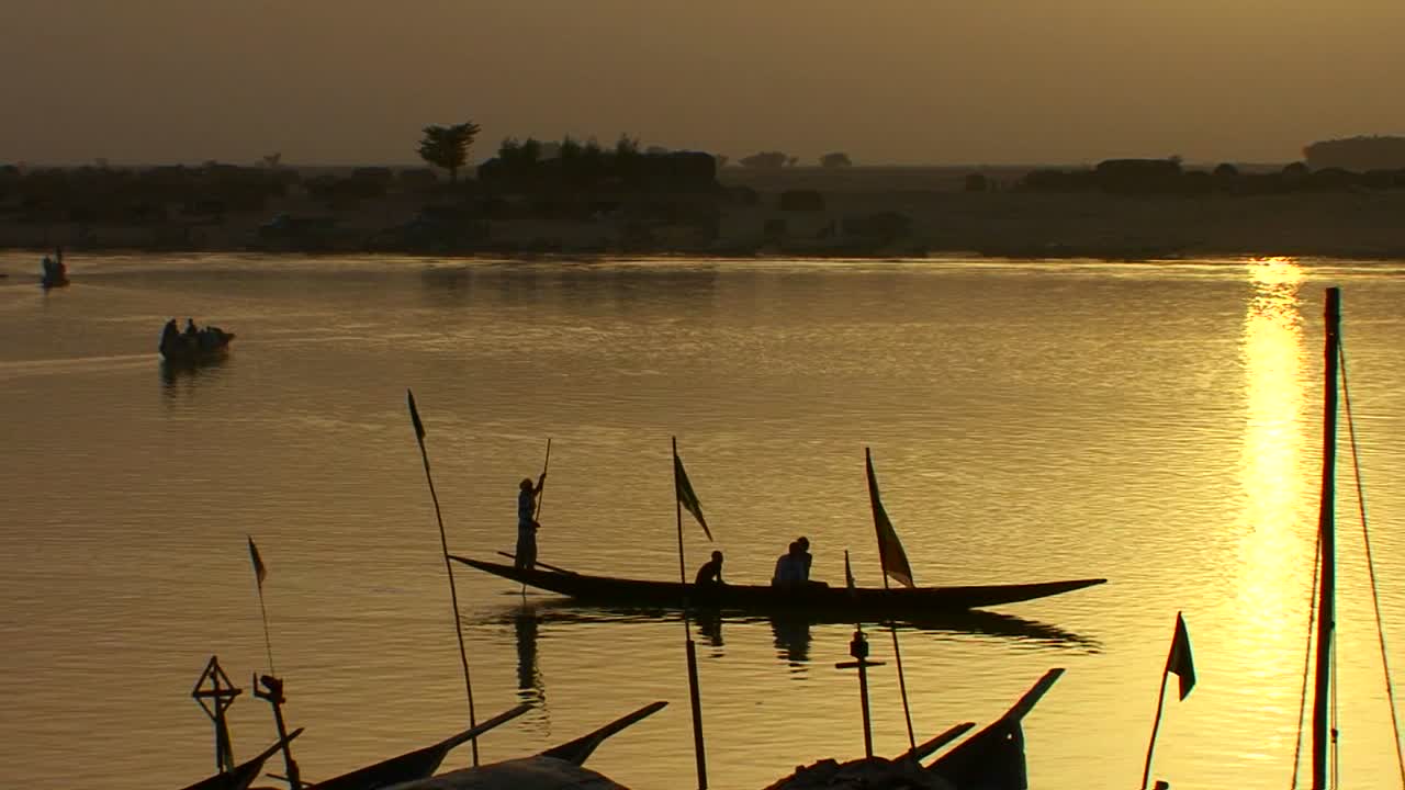 los barcos reman en el río níger en una hermosa luz dorada en mali áfrica 1