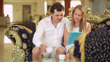 couple with touchpad on the sofa in hotel