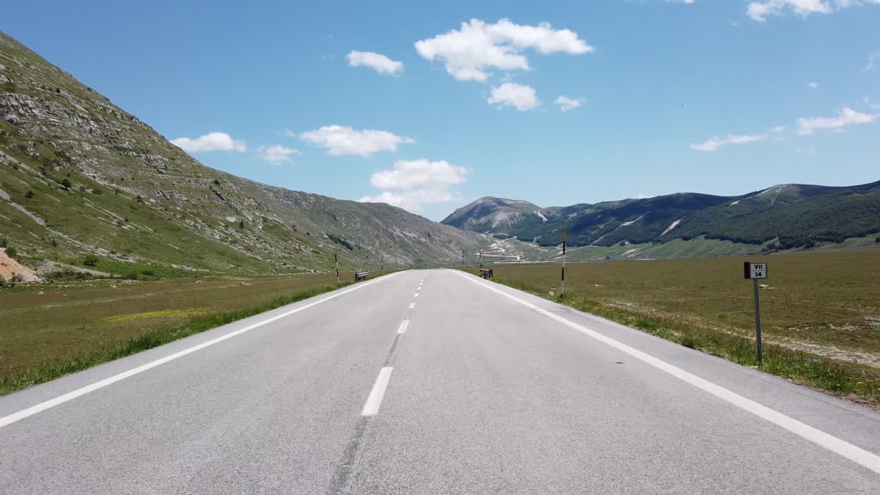 Veduta in movimento (auto, moto o bicicletta) di un paesaggio montano
