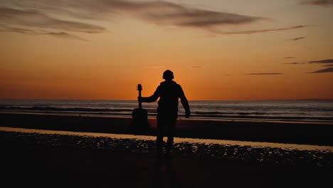 man running with guitar in back sand beach at sunset-34
