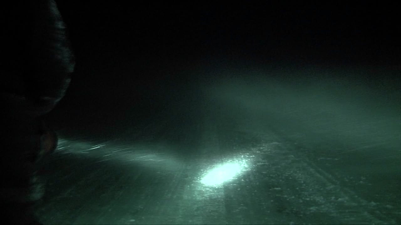 un hombre perdido en una ventisca camina con una linterna