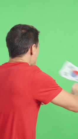 rear view of a man waving a south korean pennant