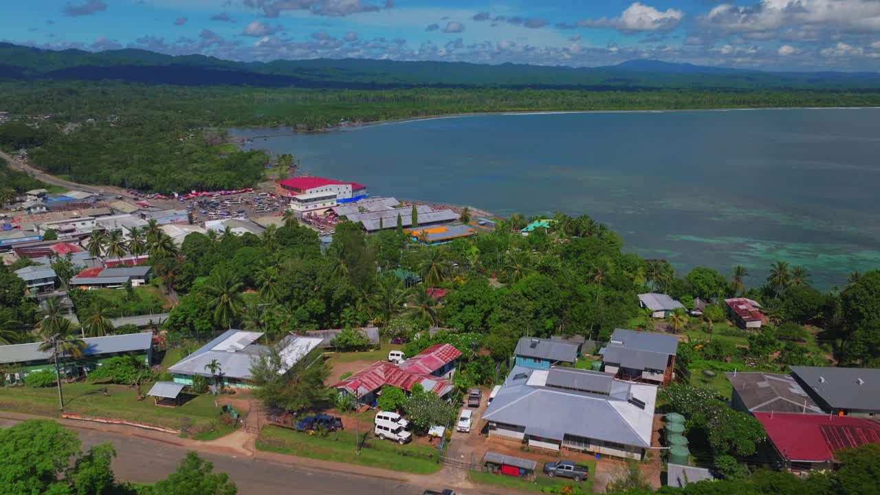 Wewak Hill Fish Market cars buildings village Boram road Wewak Papua New Guinea aerial drone downtown coastal town Sundaun Market Dogreto Bay Cape Wom Bismark Sea sunny blue sky morning forward up