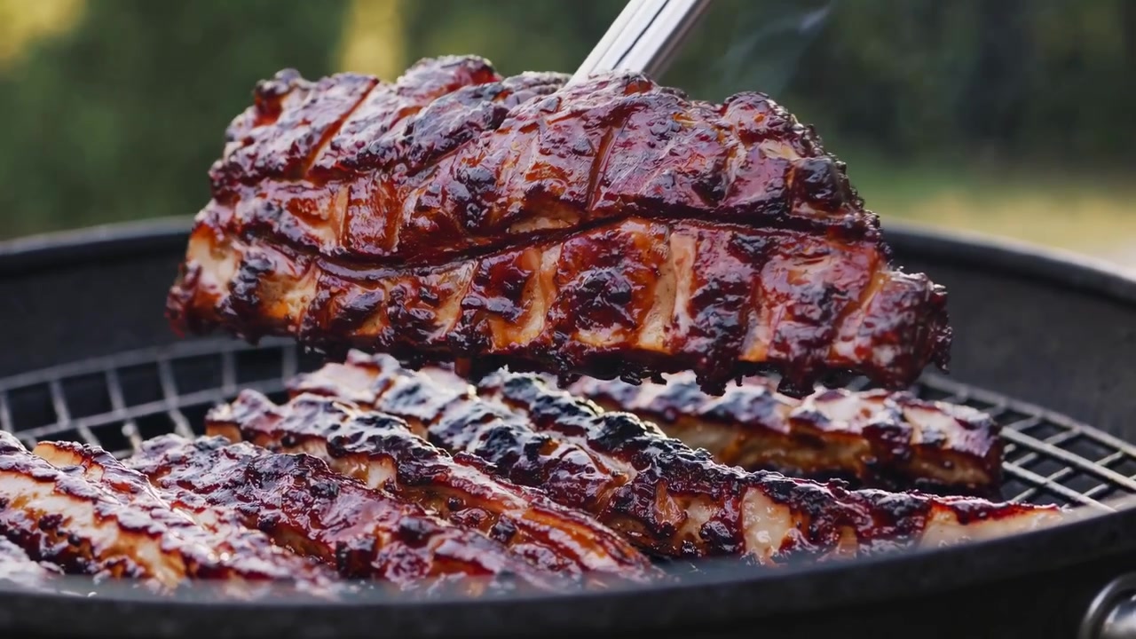 Primer plano de deliciosas costillas a la barbacoa asándose en una parrilla
