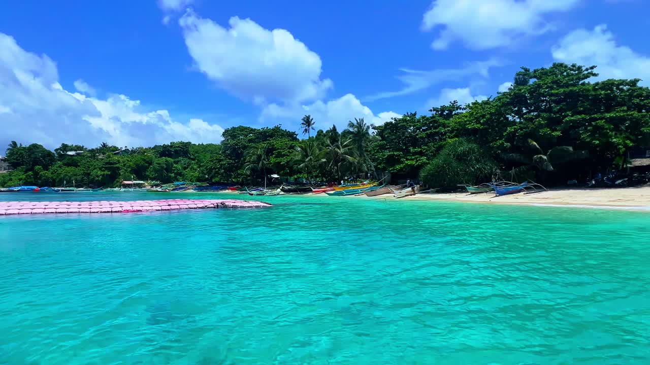 Pristine turquoise water meets lush beach and anchored boats—ideal for travel, nature, and island destination content