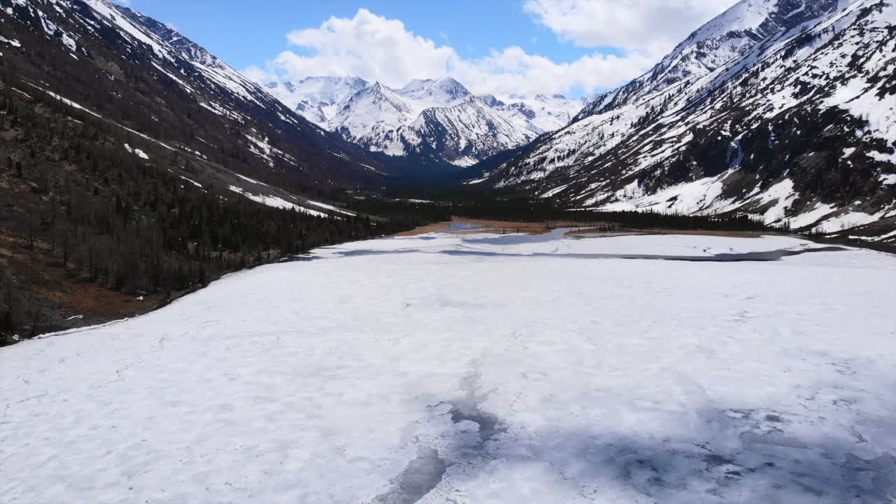 Winter Mountain Valley with Frozen Lake and Snow-Capped Peaks