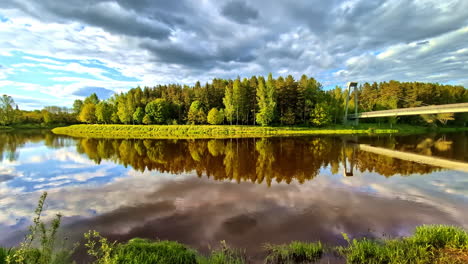scenic bend of gauja river reflecting green trees and sky under dramatic evening clouds