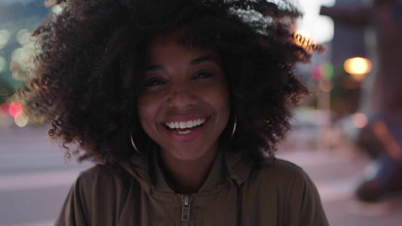 retrato de una joven negra elegante con afro riendo juguetona disfrutando de la vida nocturna en la ciudad el viento soplando el cabello estilo de vida urbano