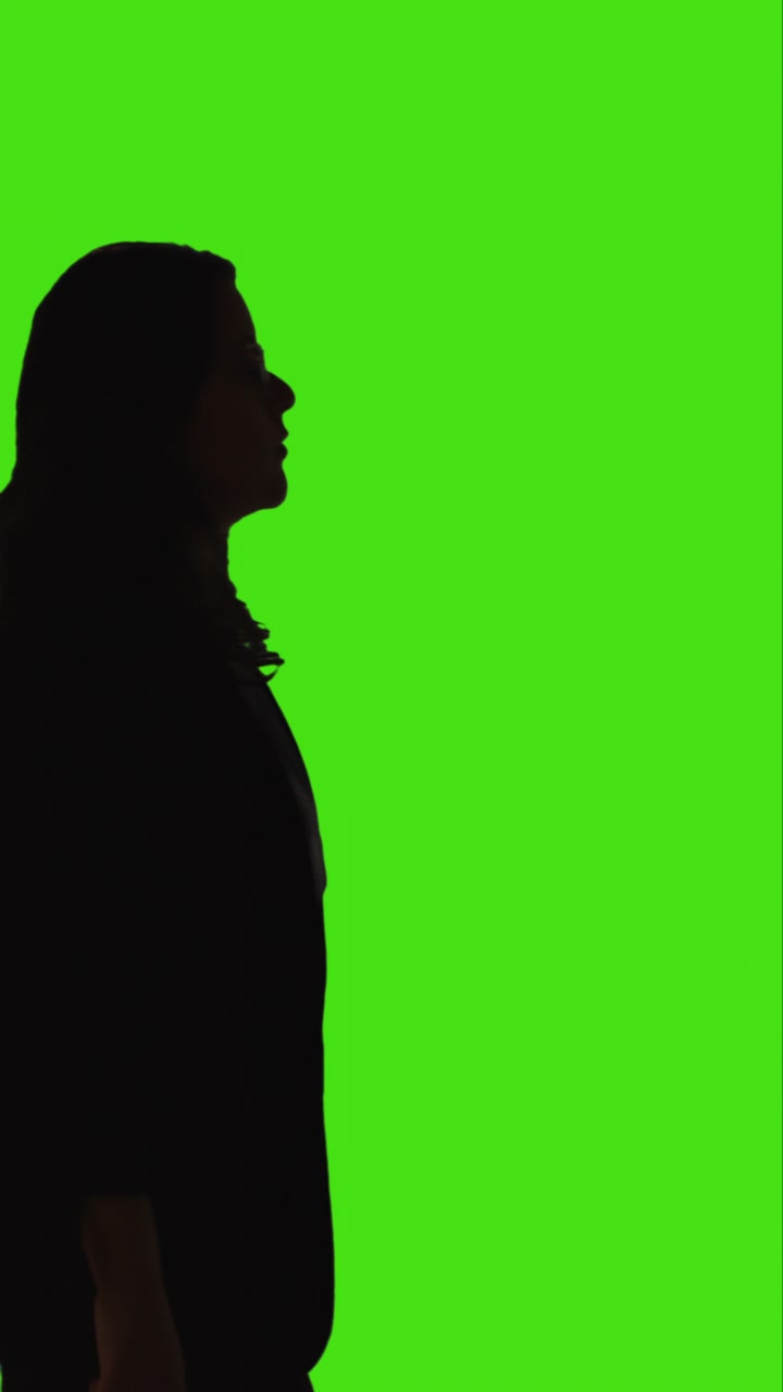 Vertical Video Silhouette Shot Of Young Woman Walking Slowly Across Frame Against Green Screen 2