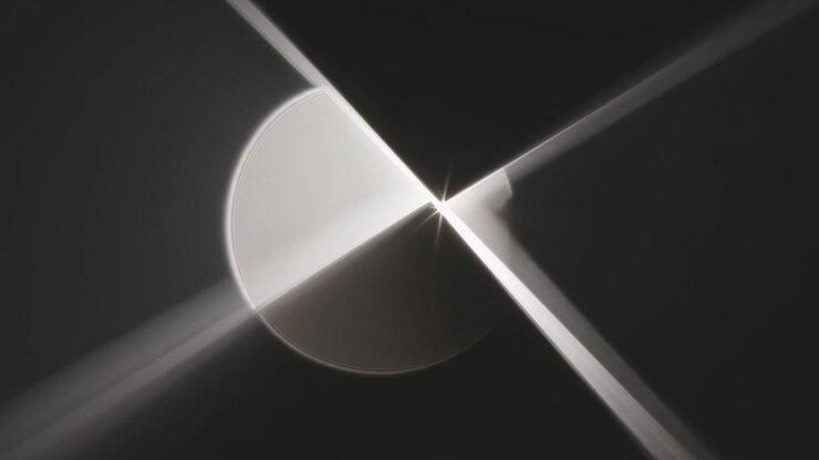 Subtle diagonal beam shift sweeping over bright disc in dark field, revealing lit arcs and flare