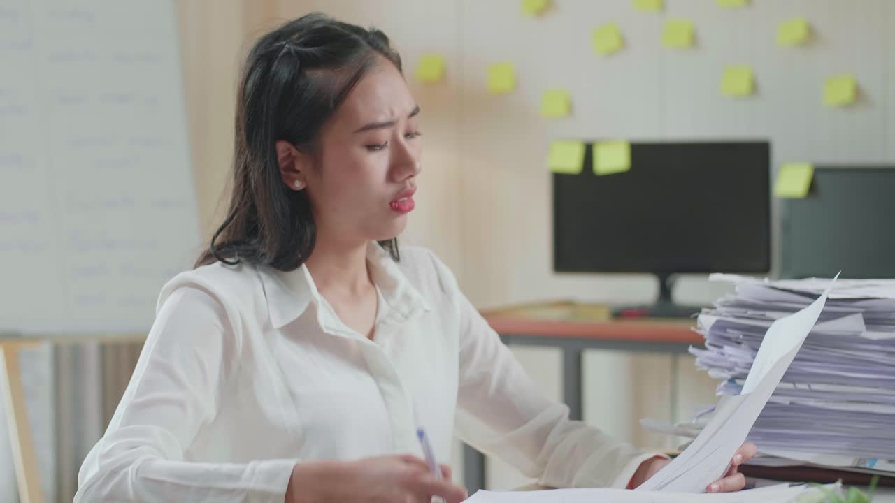 Close Up Of Asian Woman Thinking And Looking At Paper Then Raising Index Finger While Working With Documents At The Office