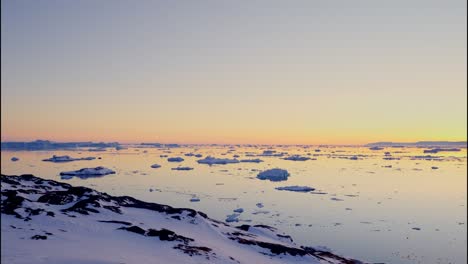 costa cubierta de nieve al atardecer sobre el fiordo de hielo de ilulissat