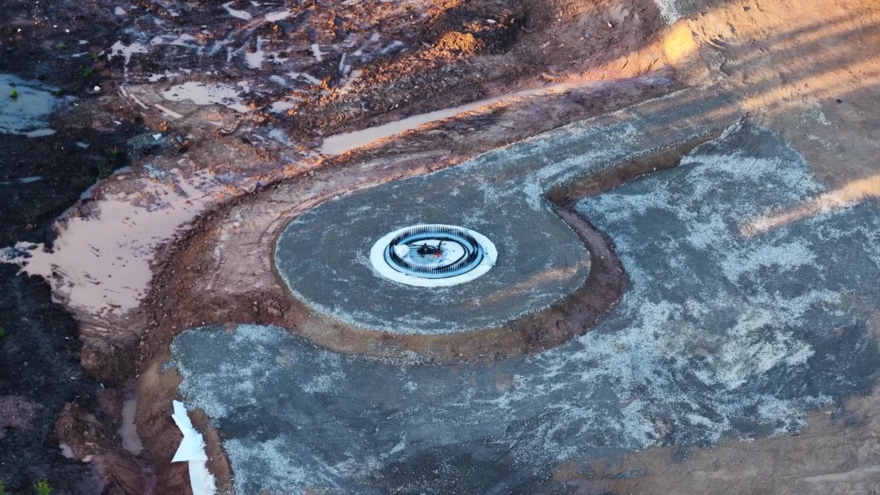 Wind turbine foundation construction site aerial view with concrete base