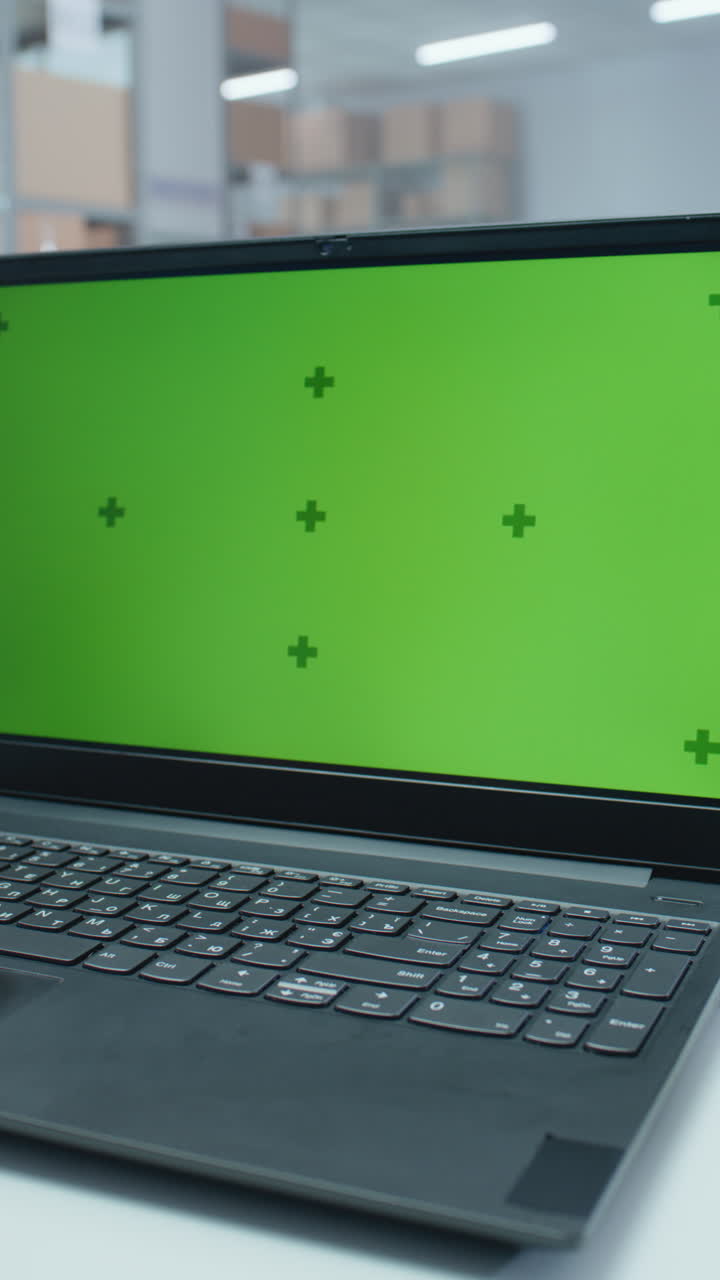 portátil con pantalla verde en un almacén