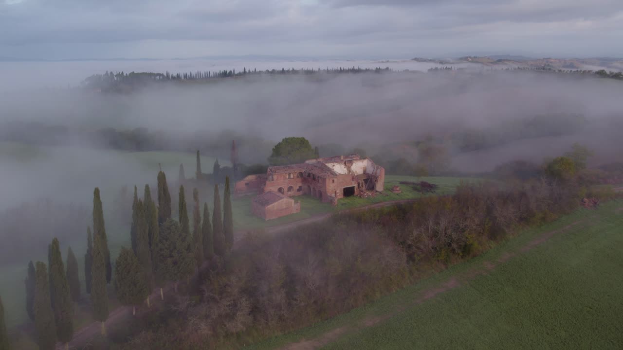 vieja casa de granja abandonada en la idílica colina de cipreses en italia con niebla