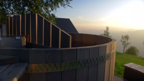 acogedor jacuzzi de madera al aire libre en la cabaña de la montaña antes del atardecer, cámara lenta de carro