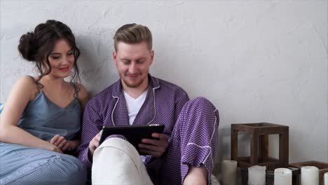 couple using a tablet in pajamas