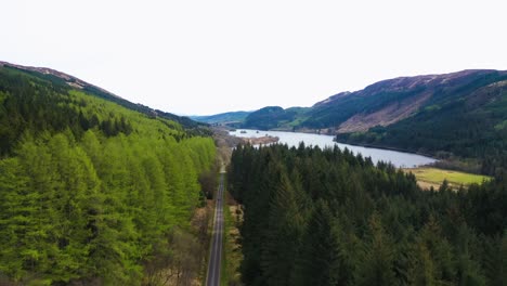 Vista-Aérea-De-La-Impresionante-Carretera-Panorámica-A-Lo-Largo-Del-Lago-Chon-En-Escocia