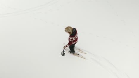 un hombre adulto con un gran sombrero de piel se filma caminando con raquetas de nieve con un gimbal dji ronin rsc 2