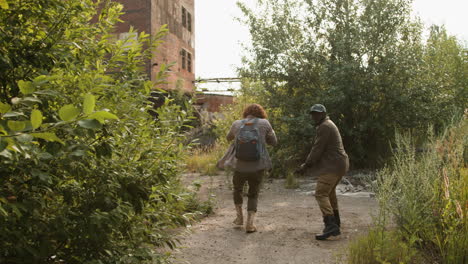 men with guns around an abandoned house