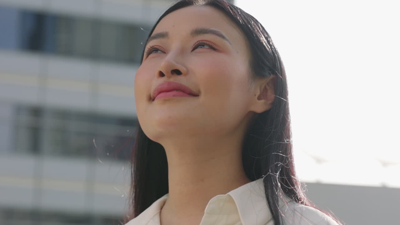 Portrait of a Confident Young Asian Woman Looking Upwards in a City
