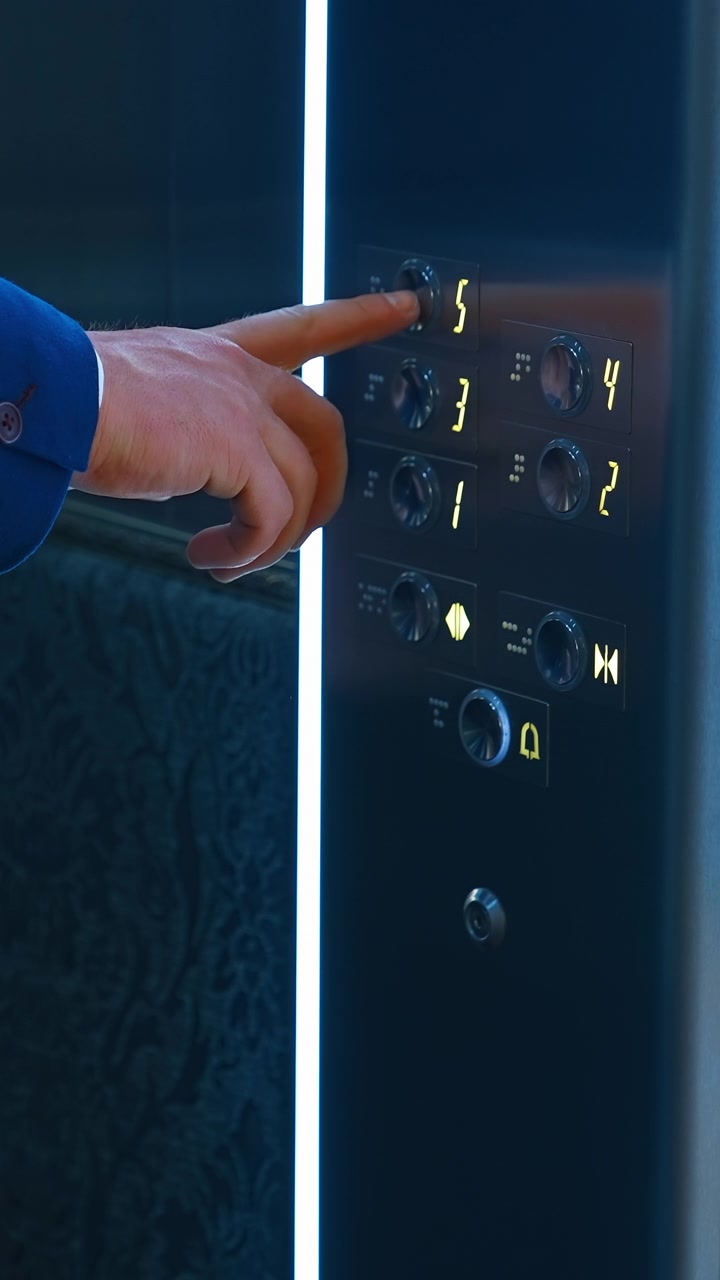 Man pressing elevator button. Traveling businessman with suitcase waiting for elevator in hotel. Vertical video