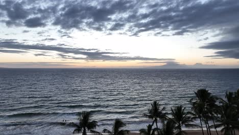 Tropical-Beach-Sunset-With-Palm-Trees-And-People-Silhouettes