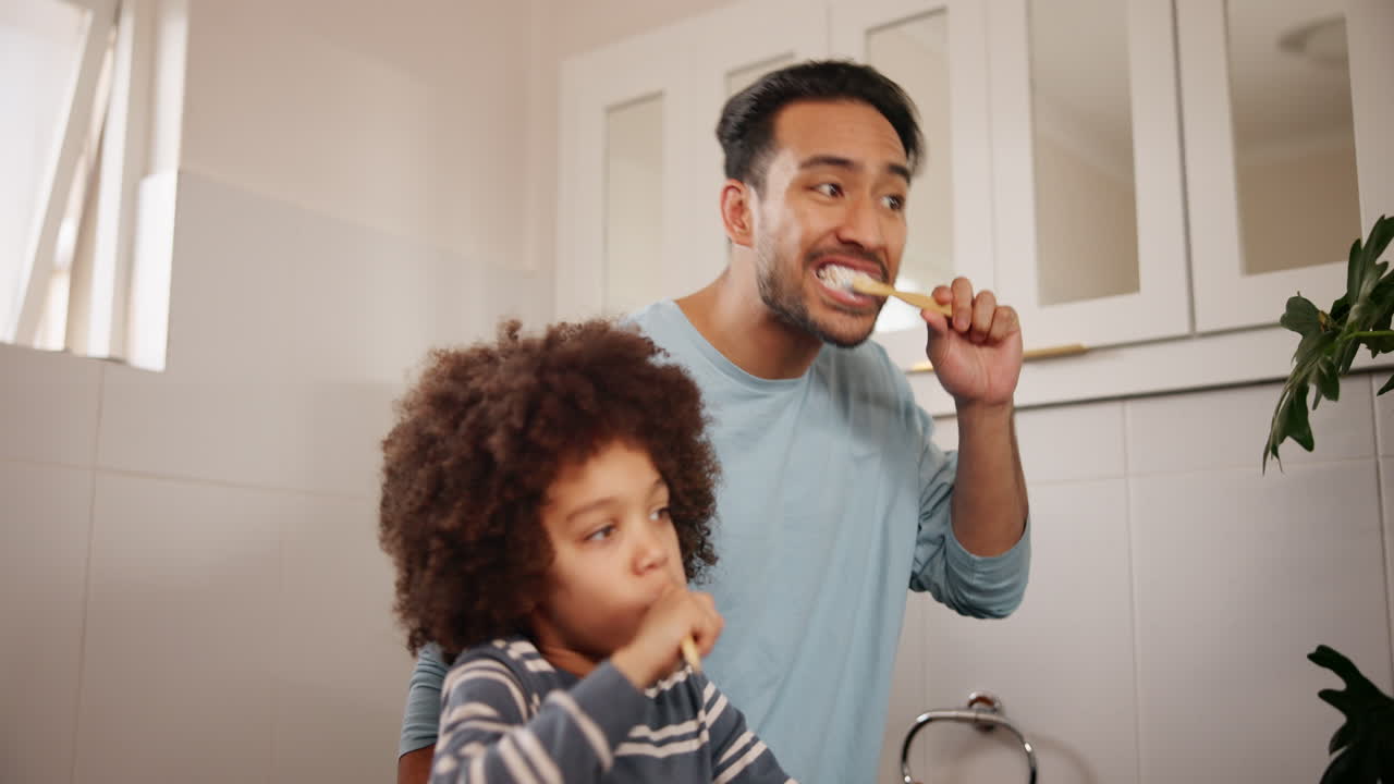 Father brushing his son's teeth