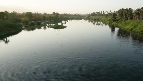 Aerial-of-the-Nile-River-,-traditional-Egyptian-sailing-boats,-in-Aswan,-Egypt,-embodying-the-concept-of-timeless-maritime-heritage-and-cultural-richness