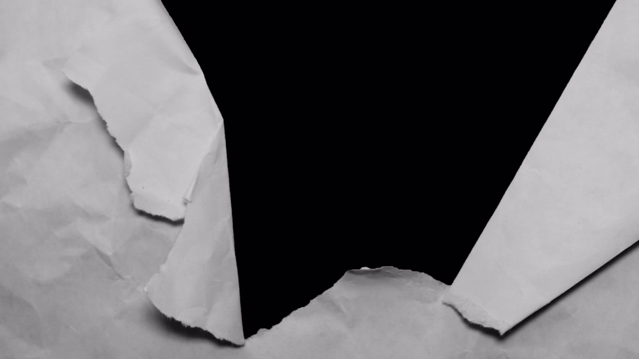Crumpled White Paper Tearing to Reveal Black Background
