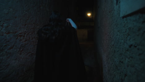 mysterious young woman walks with a lantern through the narrow streets at night