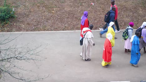 a group of christians march on the road of nairobi kenya to attend their religious gathering to be held in the morning , many people together
