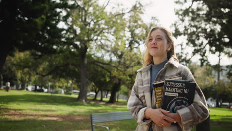 a woman with books in a park
