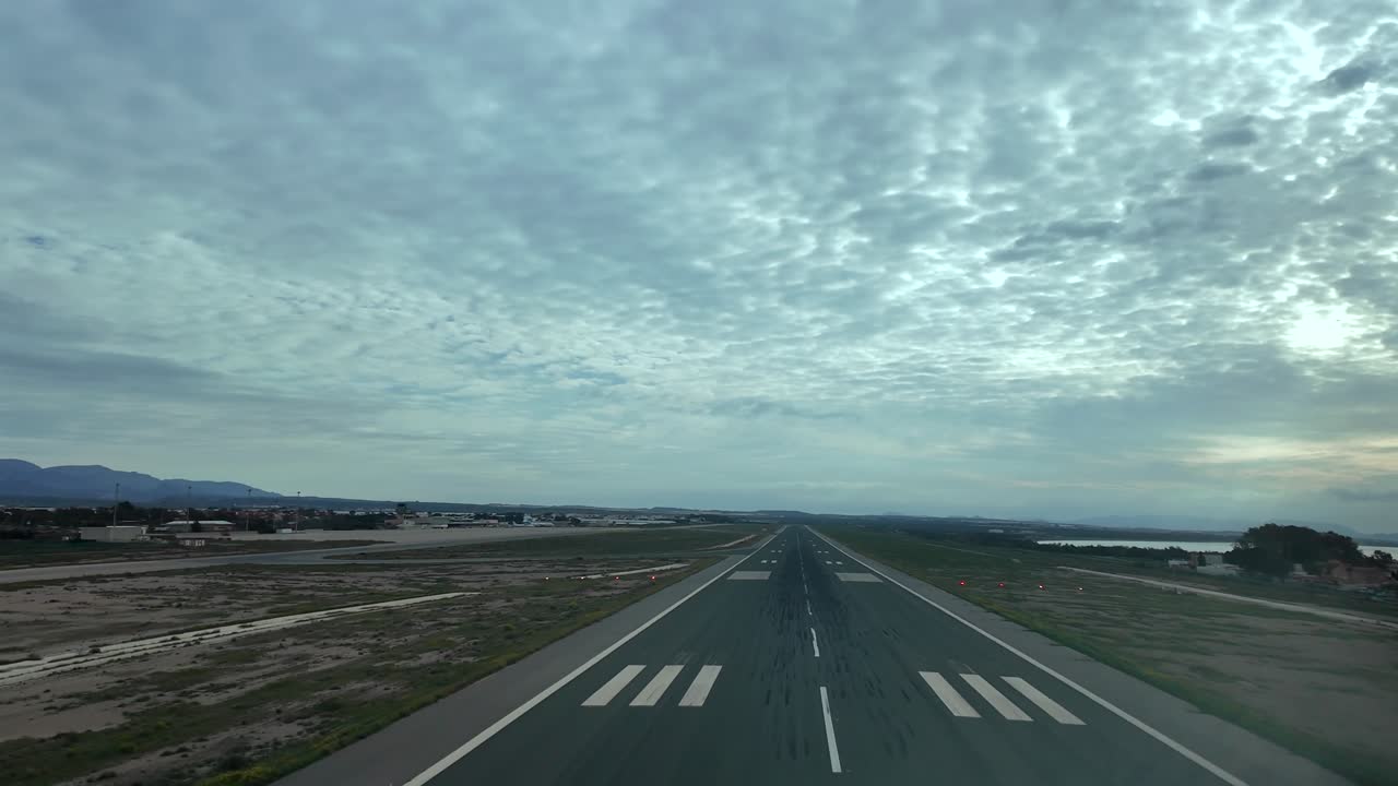 Perspectiva imersiva de piloto em uma aterrissagem em tempo real na pista do aeroporto de Almería em um dia nublado na hora azul.